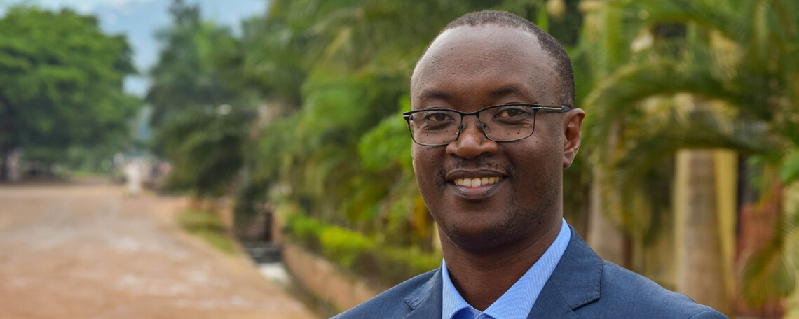 dieudonne smiles in front of green trees