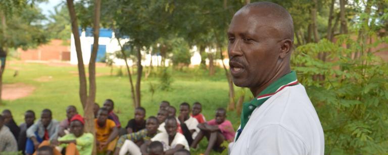Ephraim speaks outdoors to a group of young men
