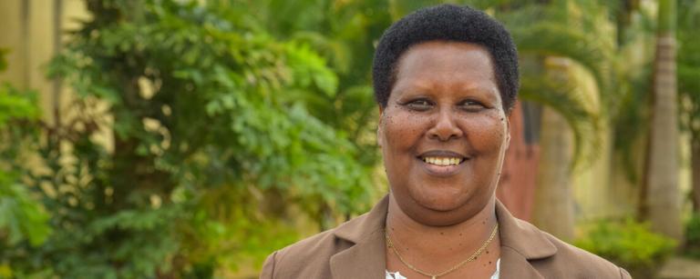 Goretti from Kings Conference Centre smiles in front of green trees