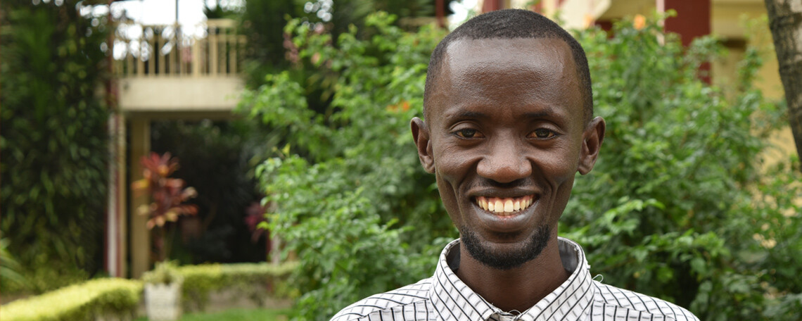 Gratien smiles in a leafy courtyard