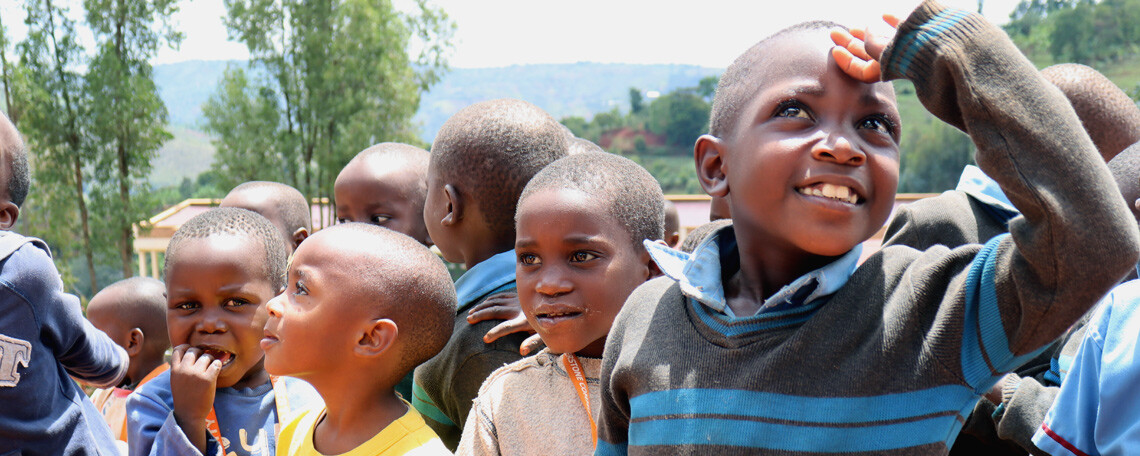Burundian Schoolchildren outside gathered and smiling, looking in all directions