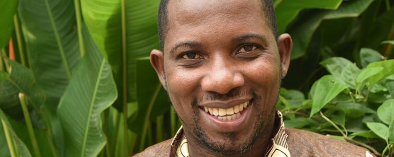 Jean Baptiste NZOHAGERA smiles in a leafy courtyard