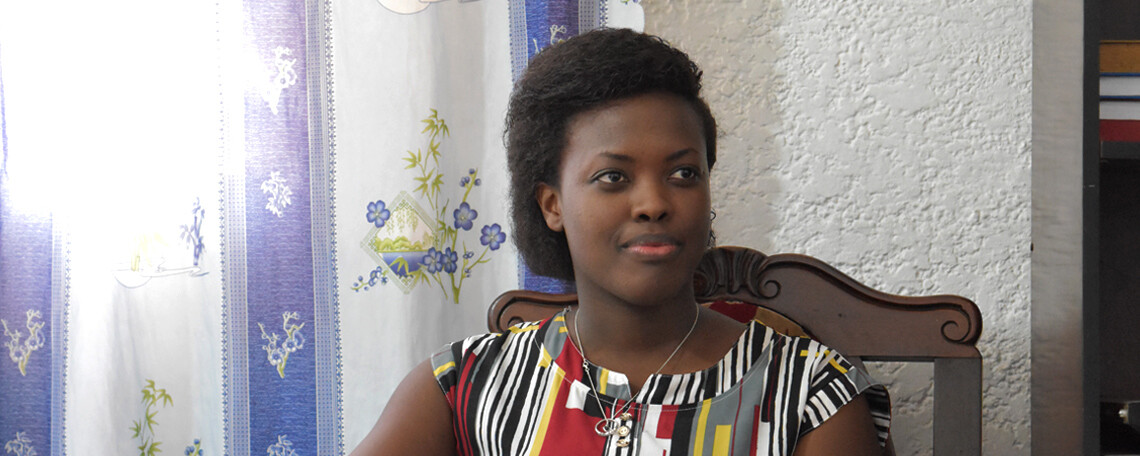 Martine Sits in a room with blue and white curtains