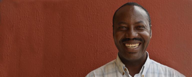 Euphrate from YFC Smiles in front of a red wall