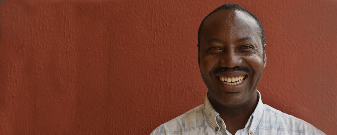 Euphrate from YFC Smiles in front of a red wall