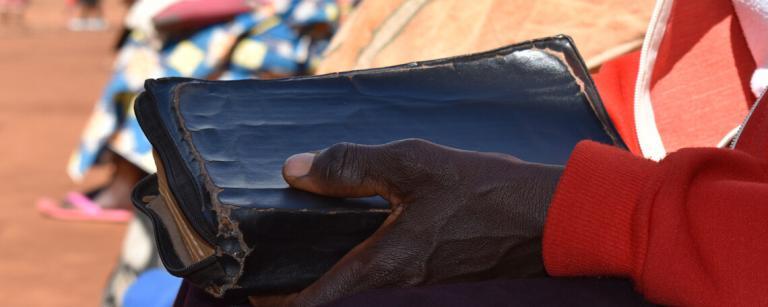 Close up of a bible held by a woman