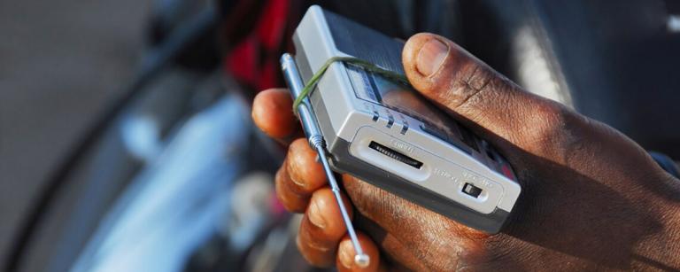 hands hold an analogue radio