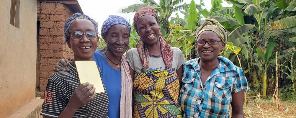 Annociate and three other ladies smiling together, one holds up a health insurance card.
